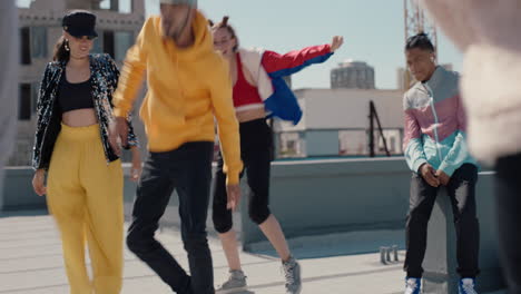 man dancing with friends on rooftop at hip hop dance party performing crazy b boy dance moves with friends cheering