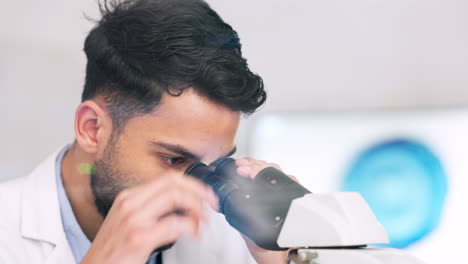 científico de laboratorio usando el microscopio para examinar