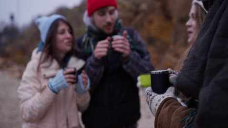 friends enjoying a hot drink outdoors in the winter