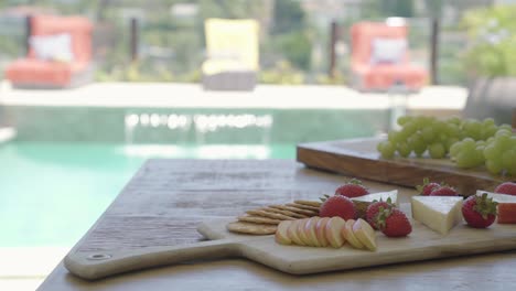aperitivo vegetariano de queso y frutas servido en un hotel de spa de lujo con piscina en el fondo