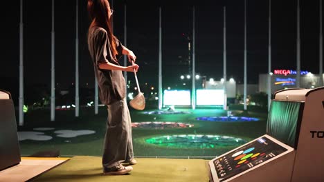 person practicing golf swing at driving range