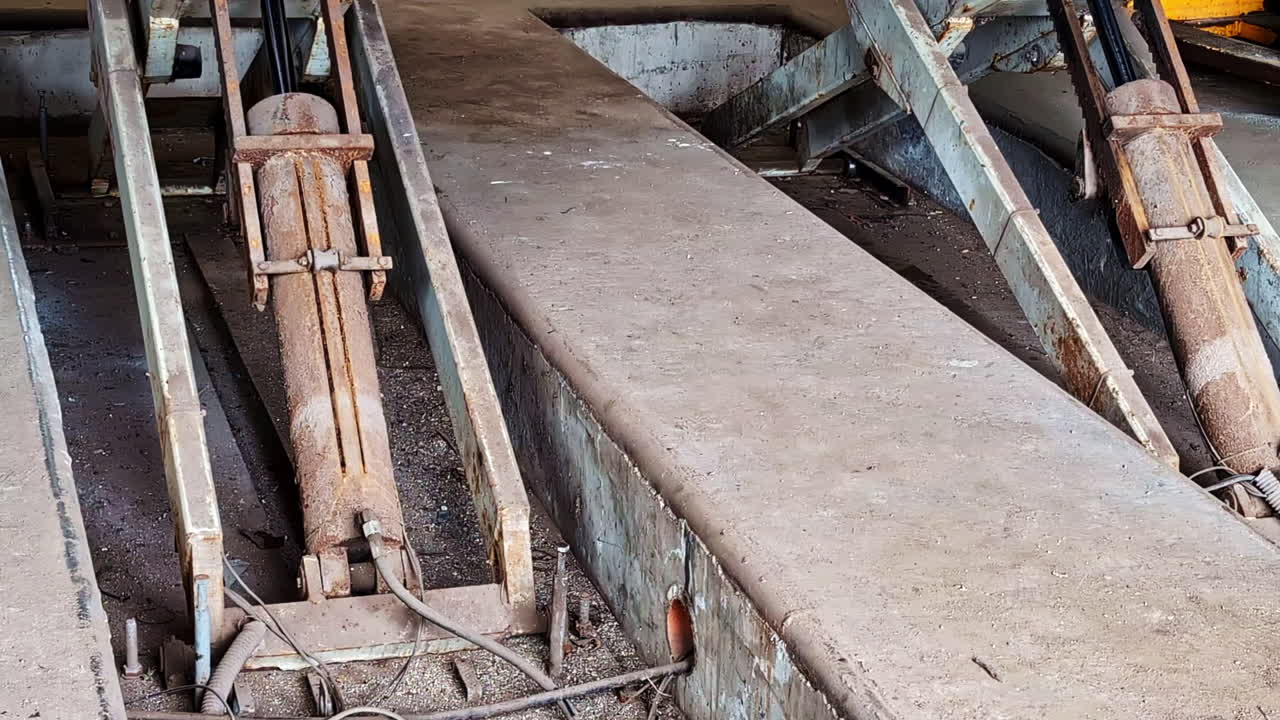 Scissor lift platform raising up in industrial workshop with hydraulic mechanism visible