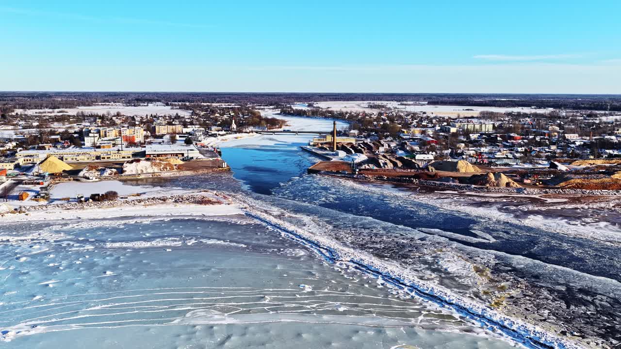 Winterse havenplaats met vaargeul door bevroren water, luchtfoto