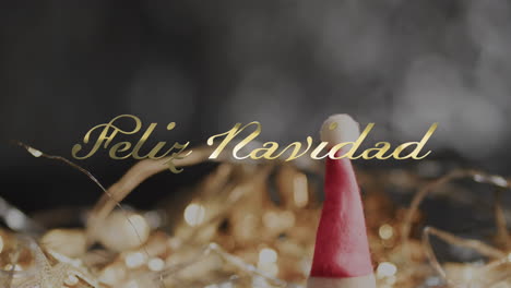 feliz navidad text over christmas hat and decorations on grey background