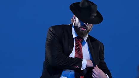 a man in a suit and fedora against a blue background