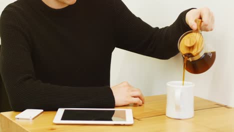 Man-pouring-coffee-from-coffee-kettle-into-the-mug