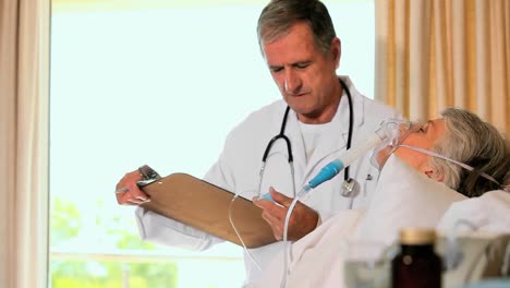 médico maduro visitando a un paciente inconsciente en el hospital