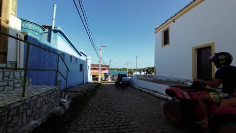 toma en cámara lenta moviéndose por un pequeño camino empedrado en la pequeña ciudad costera de barra de cunhaú en canguaretama, rio grande do norte, brasil con vista al océano en un día de verano