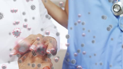 animation of macro coronavirus covid-19 cells spreading over biracial hands