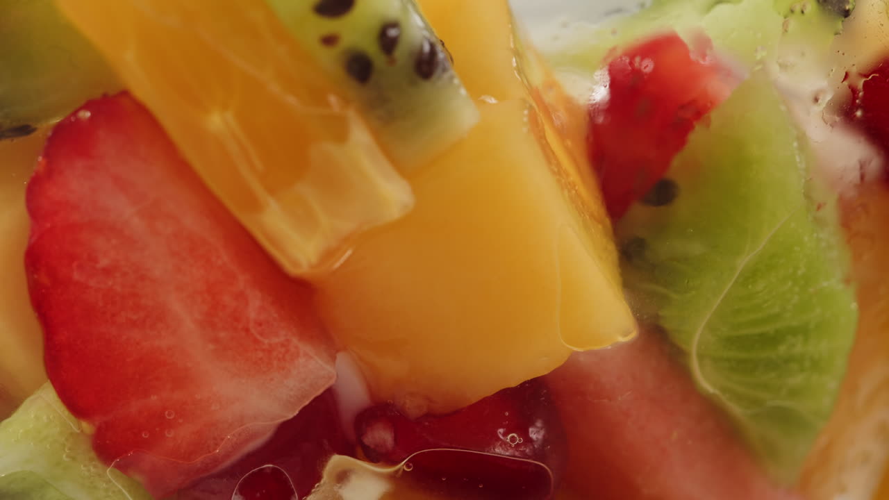 Pouring Yogurt Over Fresh Colorful Fruit Salad