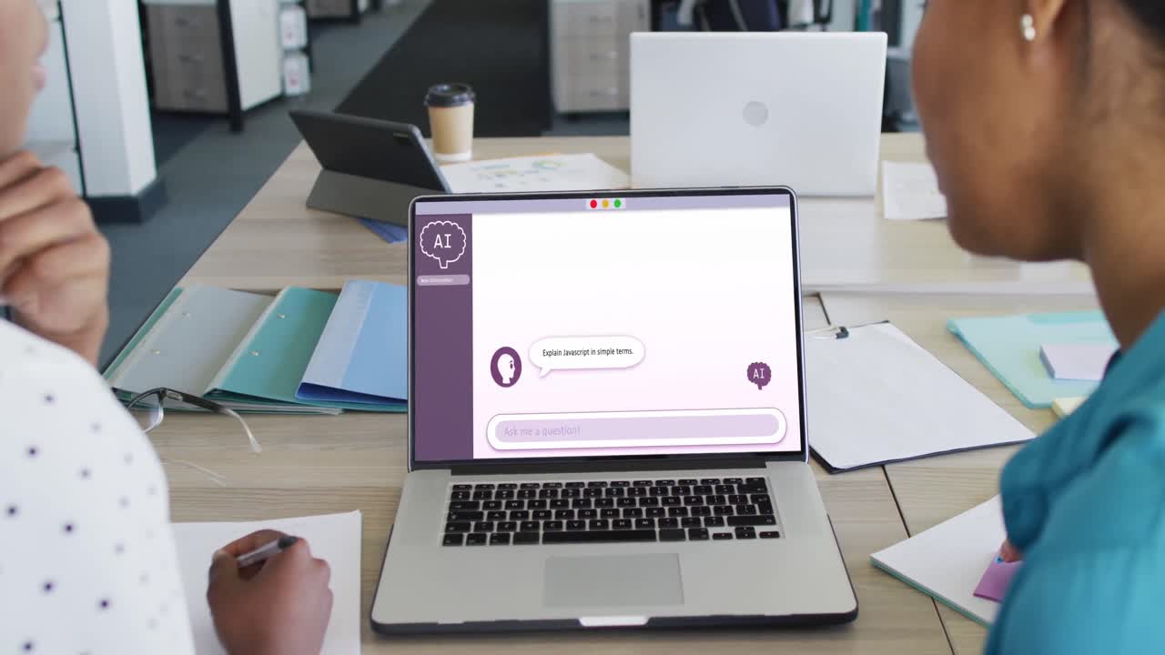 mujeres de negocios diversas que usan computadoras portátiles con procesamiento de datos en la pantalla en la oficina