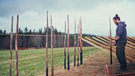 man building skigard - a traditional norwegian fence - wide shot