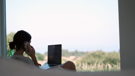 home office remote work young professional engaged in a business call with a scenic backdrop using her laptop