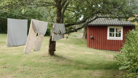 laundry drying in the sun on drying line in front of swedish farmhouse