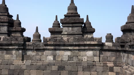 wall of borobudur temple covered with stupa sculptures.