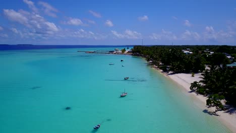 aerial rise, old fashioned dhoni boats in brilliant aquamarine waters of secluded maldives island, 4k shot