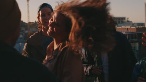 Mujer-Caucásica-Bailando-Grupo-De-Amigos-Diversos-Pasando-El-Rato-Disfrutando-De-La-Música-De-Baile-De-La-Fiesta-En-La-Azotea-Al-Atardecer-Bebiendo-Divirtiéndose-En-La-Reunión-De-Fin-De-Semana