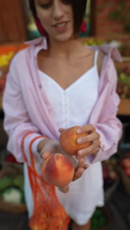 woman buying peaches at a farmers market