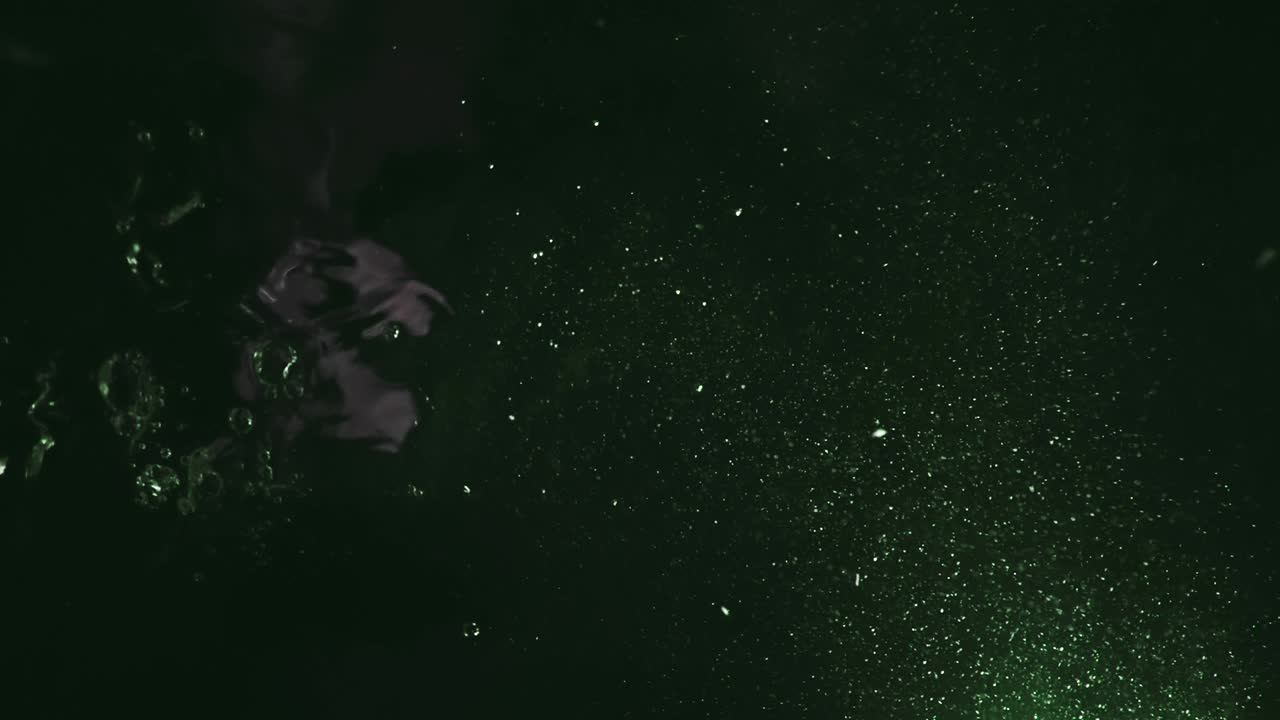 물속의 다채로운 거품이 느린 동작으로 표면으로 올라오는 아래쪽 영상. 가까이 가서, 신선한 소다, 탄산수, 거품이 용해되는 것을 혼합합니다.