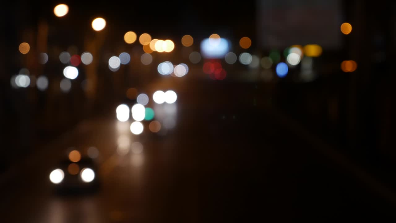 hermoso bokeh brillante en el fondo oscuro borroso por la noche. el redondo bokeh colorido brilla de las luces de los coches en la calle de la ciudad. fuera de foco con borroso. luces de la ciudad sin enfoque. bokeh de tráfico. concepto abstracto