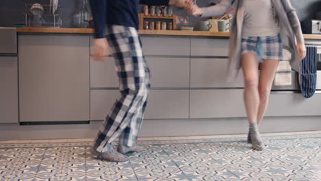 unrecognizable happy young couple newly wed dancing listening to music in kitchen wearing pajamas  morning at home in love