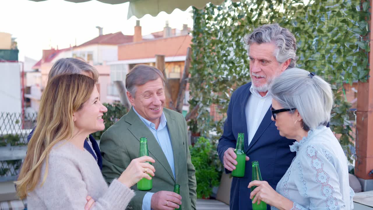 Happy Group of Friends Socializing and Drinking Beer on a Rooftop Terrace