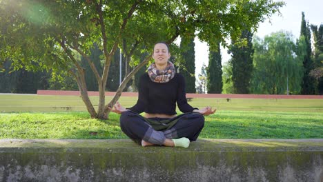yoga-teacher-laughing-and-talking-in-lotus-position,-at-the-end-she-smile