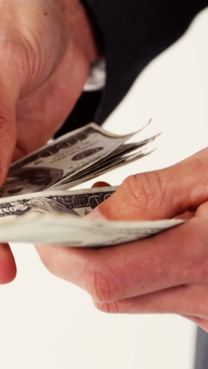 Mid-section of man counting hundred dollar note