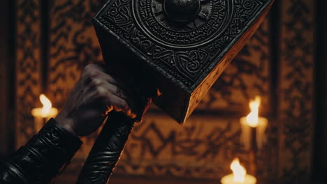 viking hammer in a dark room with candles