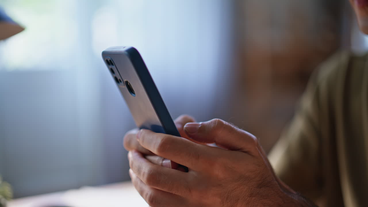 Guy fingers tapping cellphone in home office closeup. Business man messaging