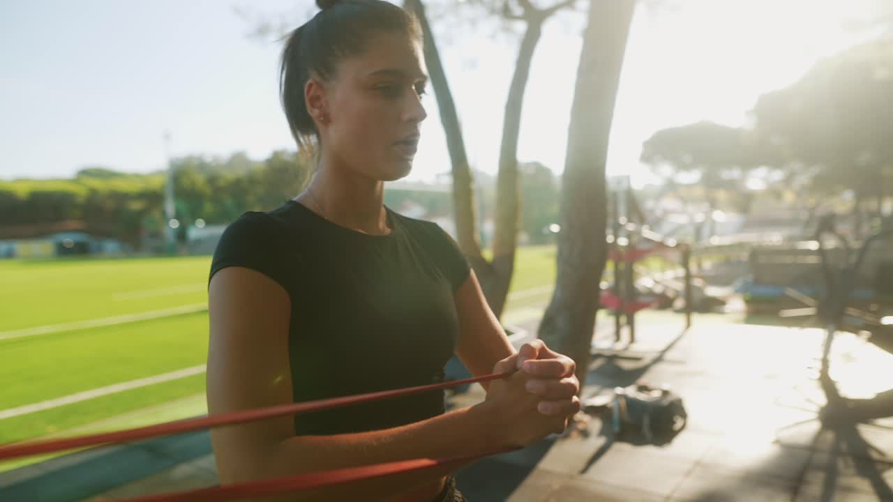 야외에서 저항 밴드로 운동하는 여성