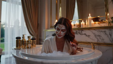 woman relaxing in a luxurious bath with a facial mask