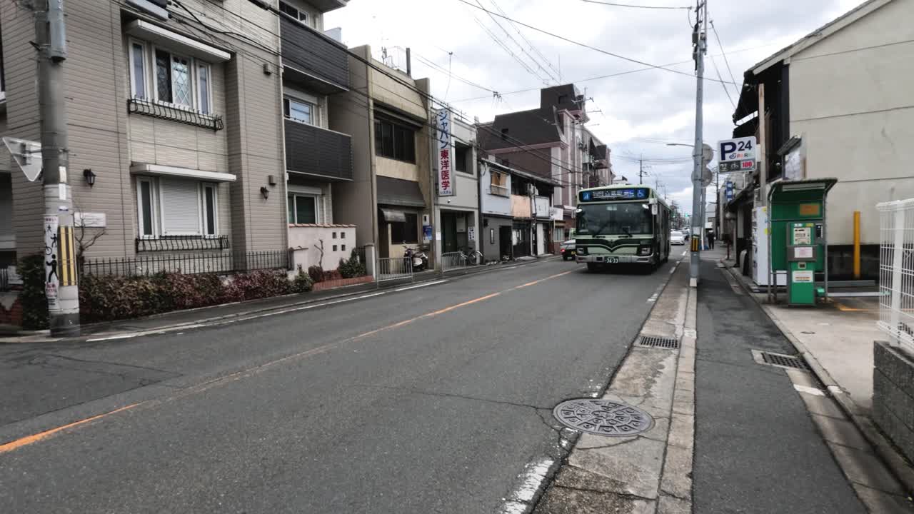 초록색 버스가 교외 거리를 따라 이동합니다.