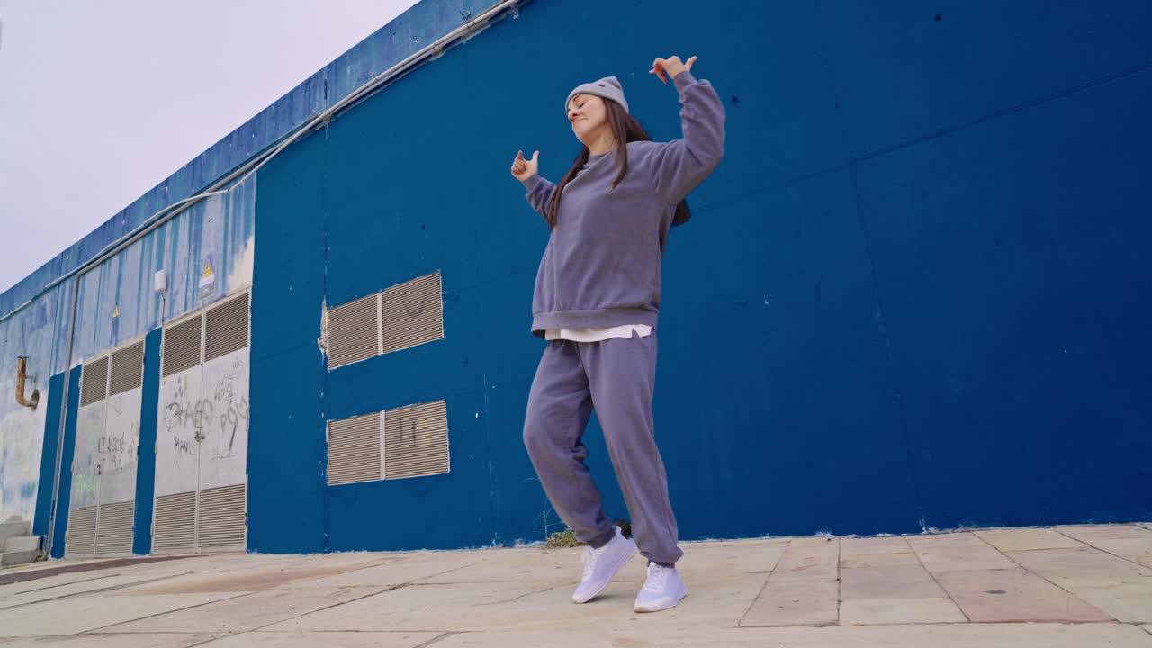 Woman Dancing in Front of Blue Wall