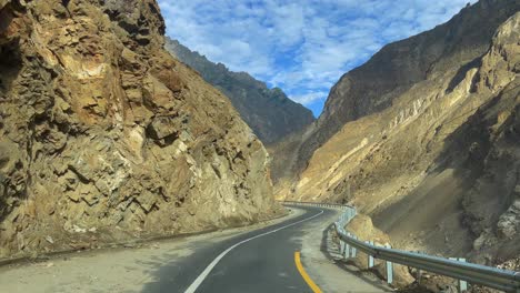 drivers pov shot driving through jsr road with steep mountains and ditch on either side of the road in skardu, pakistan