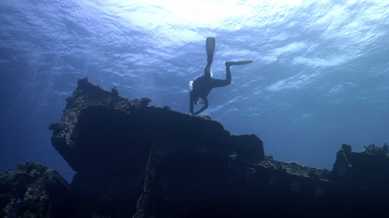 A scuba diver glides along the exterior of the tilted Giannis D shipwreck at Sha'ab Abu Nuhas reef in the northern Red Sea off Egypt