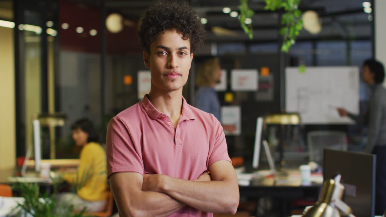 retrato de un feliz hombre de negocios biracial mirando a la cámara en la oficina