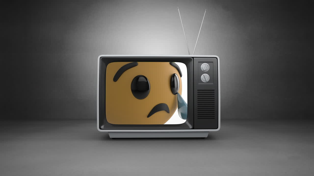 Digital animation of crying face emoji on television screen against grey background