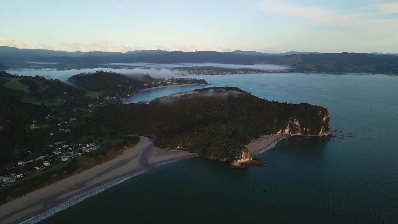일출 시 뉴질랜드 코로만델 반도를 따라 언덕 위로 안개가 굴러간다