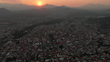 aerial view of a city at sunset with mountains in the background