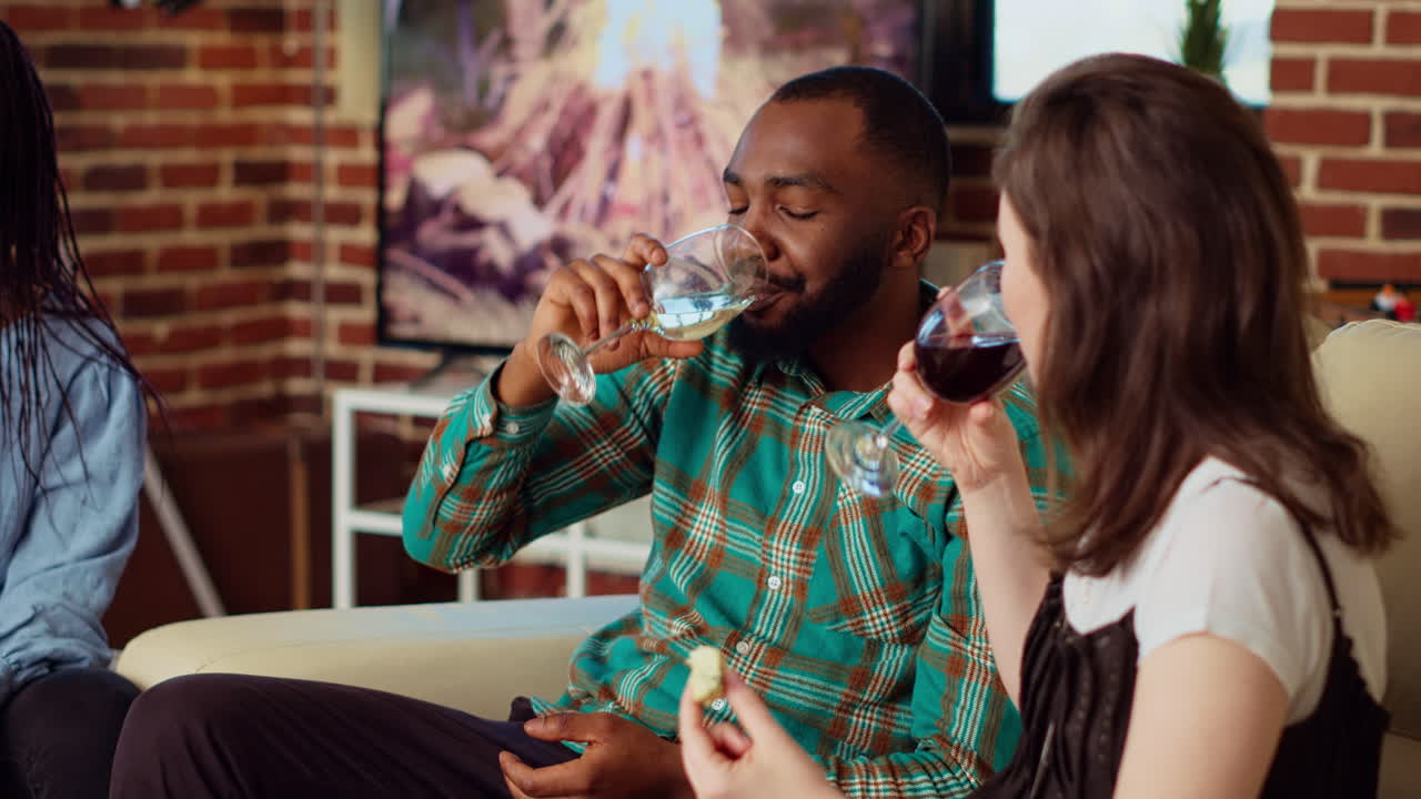 Multiracial couple invited at friends birthday, talking and drinking alcohol