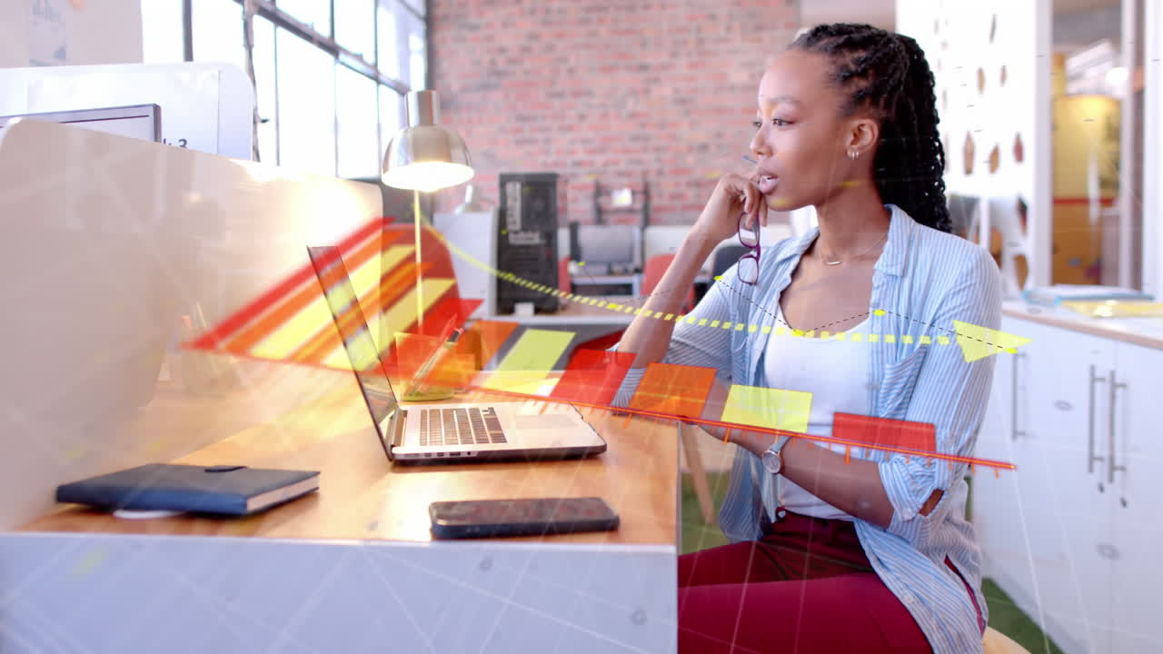 Animation of diagram over biracial businesswoman using laptop in office