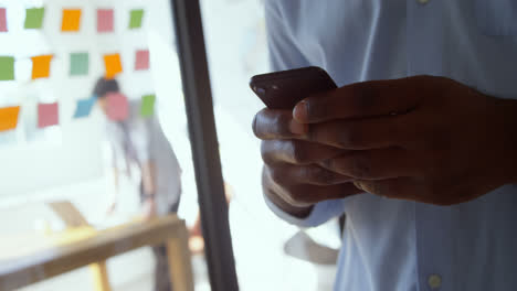 Close-up-of-young-black-businessman-working-on-smartphone-in-a-modern-office-4k