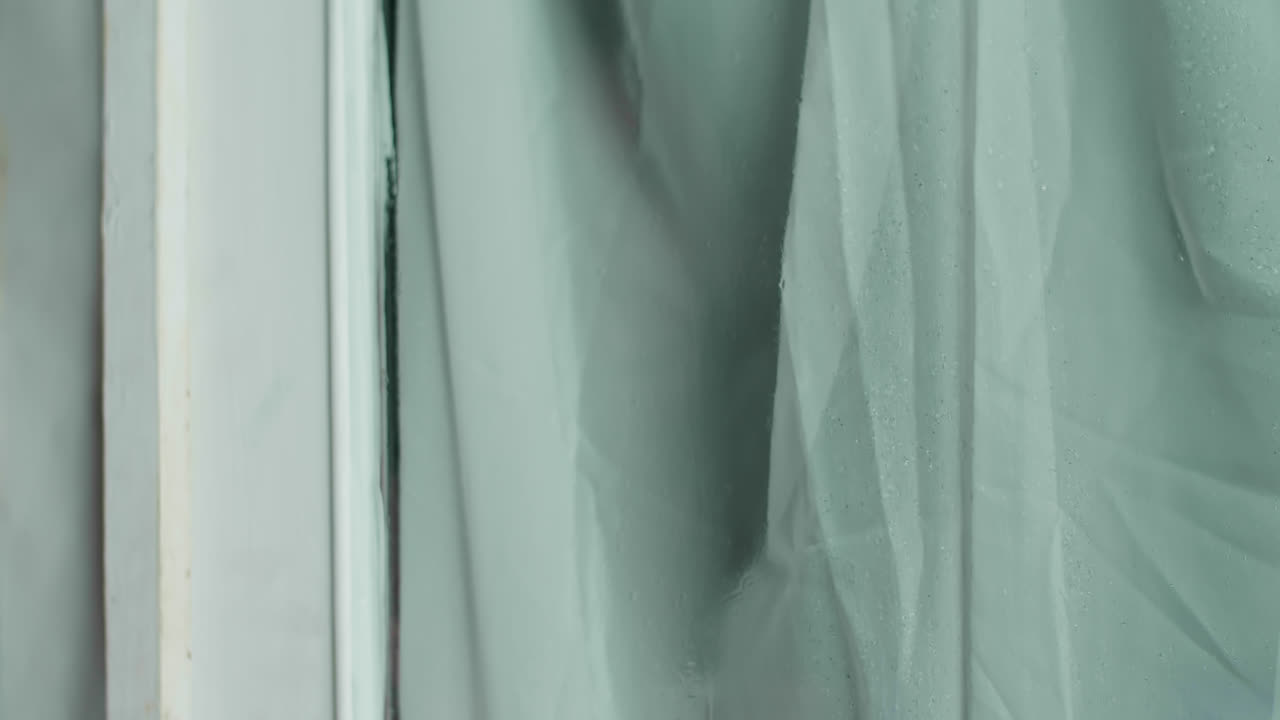 Woman looking out a window on a rainy day