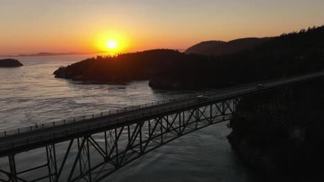 Toma-Del-Héroe-De-Los-Autos-Que-Cruzan-El-Puente-Del-Paso-Del-Engaño-Con-La-Puesta-De-Sol-En-El-Fondo