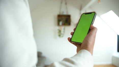 Toma-En-Cámara-Lenta-De-Un-Hombre-Que-Sostiene-Un-Teléfono-Inteligente-Con-Pantalla-Verde-Moviéndose-En-Un-Fondo-Blanco-Aislado