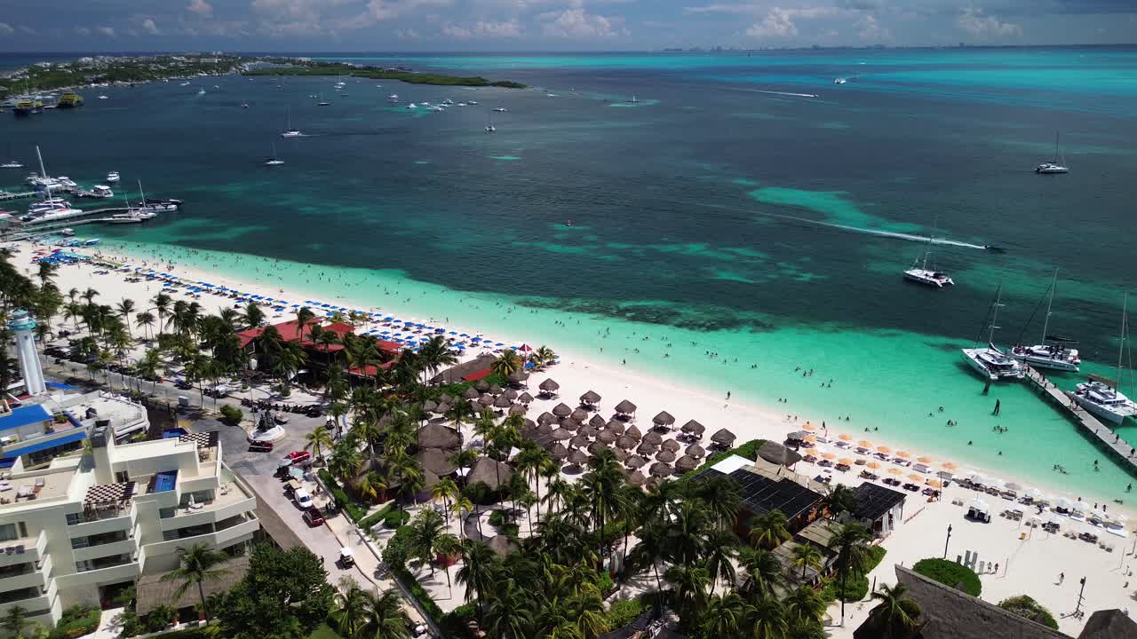 공중에서 열대 해수면이  모래와 밀집한 숲을 가진 활기찬 해안선을 만나는 정적 각도입니다.