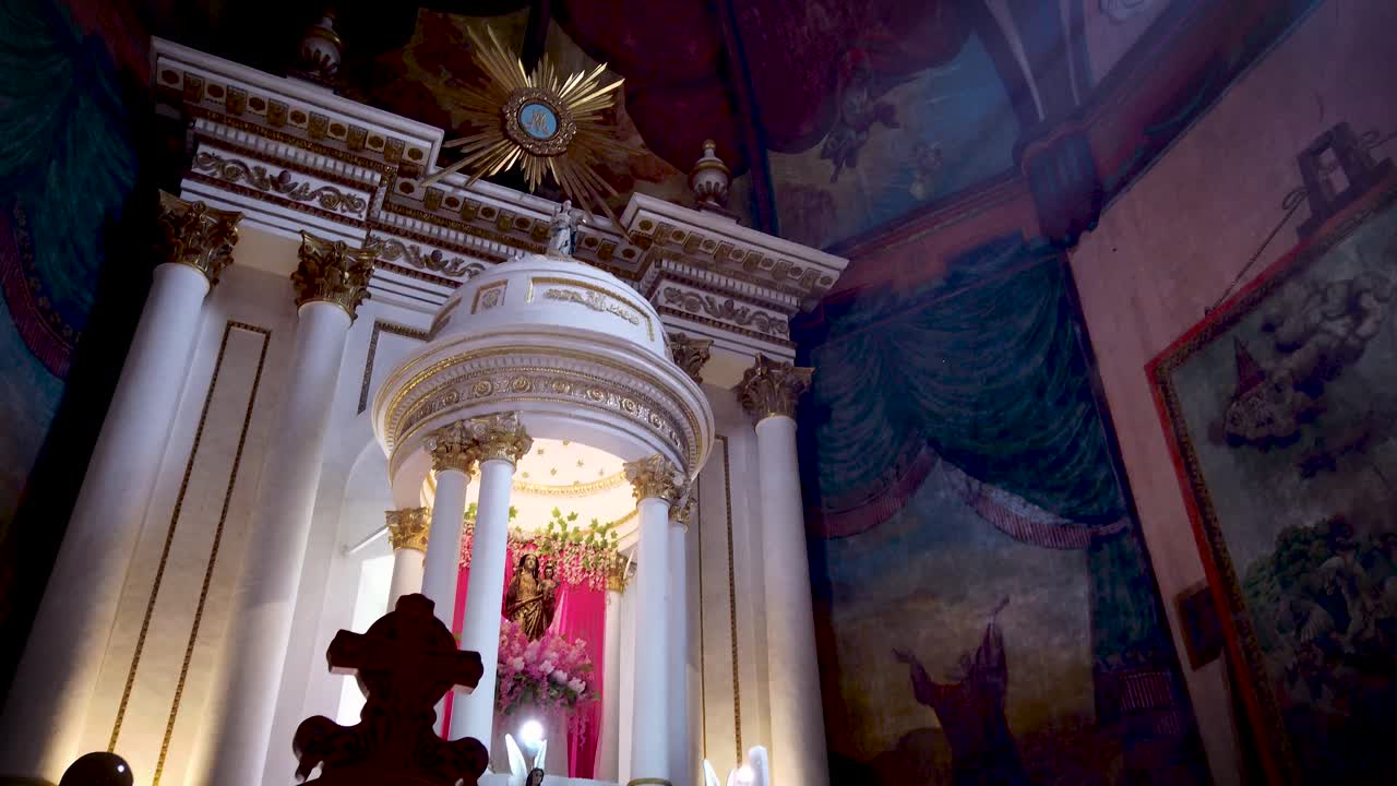 Orbital shot with ascending and descending movement of the altar and mural painting in the presbytery of the Parish of the Nativity of Mary in Tepoztlán, Mexico