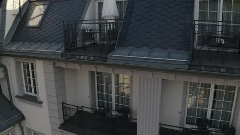 white wedding dress hangs on special hanger in doorway of balcony of luxury house, aerial view