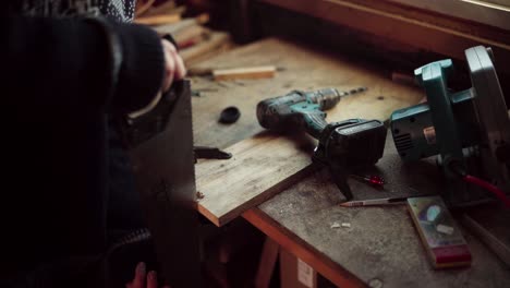 the man employs a saw to shape the edge of the wooden plank intended for the diy hot tub - close up